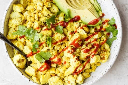 Peanut-ginger tofu scramble topped with avocado and coriander