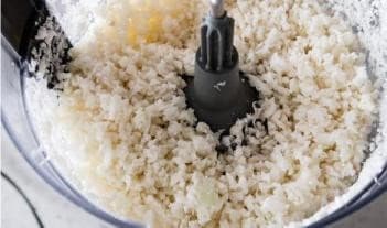 Cauliflower florets being pulsed into cauliflower rice